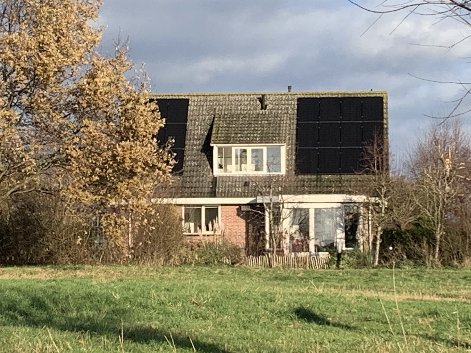 Woning met wit geschilderde kozijnen en dakkapel.